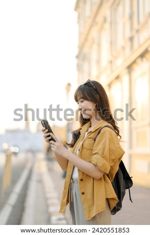 Traveler asian woman 30s using smartphone for navigation destination on the urban street at Bangkok, Thailand.