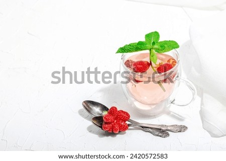 Strawberry tea concept. Good morning concept. Teapot, ripe fruits, healthy beverage. Hard light, dark shadow, white background, copy space