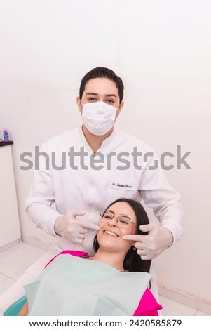 Dentist showing the perfect smile of a young girl in the dental office - vertical image.