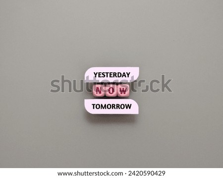 Wooden cubes with text yesterday, now, tomorrow on gray background. Choice of present moment.