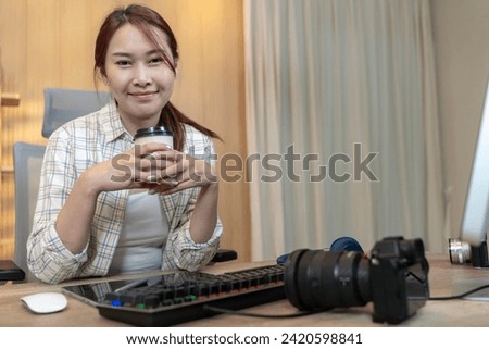 Freelance female photographer working happily from home Royalty-Free Stock Photo #2420598841