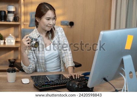 Freelance female photographer working happily from home Royalty-Free Stock Photo #2420598843