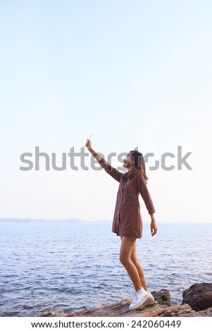 portrait of young beautiful woman rising up smart phone to sky use for feeling of human communication by hi-technology on wireless mobile phone 
