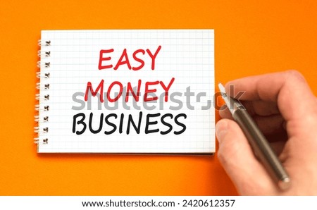 Easy money business symbol. Concept words Easy money business on beautiful white note. Beautiful orange background. Businessman hand. Easy money business concept. Copy space.