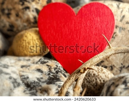 Lent Season, Holy Week and Good Friday Concept - crown of thorns with blurry red heart shape with rocks background. Stock photo.