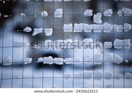 Winter landscape concept. Snow on a metal square fence. Snow on background. High quality photo