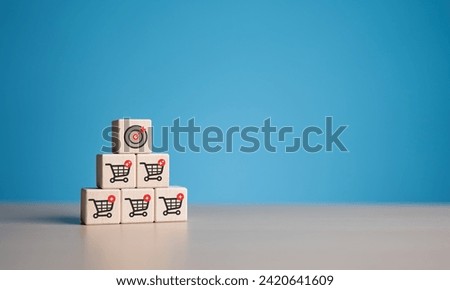 Business target dartboard and shopping cart icon on wooden cubes. Increase sale volume for higher company profit, shopping trolley cart symbol for total sales target goal, achievement, aiming concept.