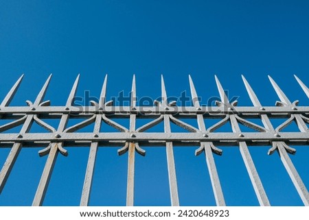 wrought iron railing, old factory gate with allegorical elements fixed with rivets, the painting prevents the rust that tends to create on these iron gates. Royalty-Free Stock Photo #2420648923