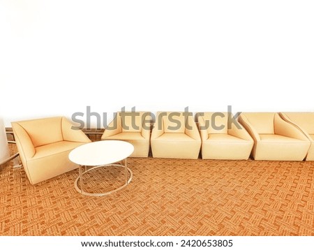 Blurred picture of Modern furniture that decorates place beautifully, orange upholstered sofa armchair placed in living room of house or in lobby of hotel to welcome guests and decorate.