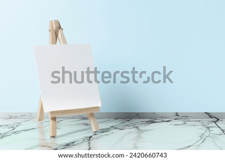 wooden easel with blank canvas indoors