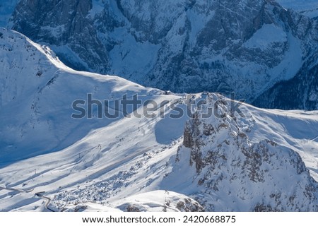 Ski resort in the Dolomites. Mountain recreation place. Ski slopes in the Dolomites on a clear sunny day. Alpine skiing sport and recreation. Royalty-Free Stock Photo #2420668875