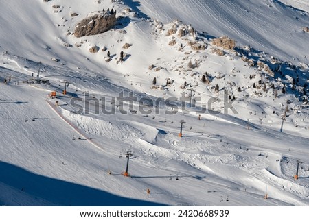 Ski resort in the Dolomites. Mountain recreation place. Ski slopes in the Dolomites on a clear sunny day. Alpine skiing sport and recreation. Royalty-Free Stock Photo #2420668939
