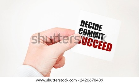 Businessman holding a card with text DECIDE COMMIT SUCCEED ,business concept