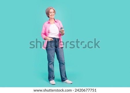 Full size photo of intelligent pensioner person look at smartphone choosing product in eshop isolated on turquoise color background