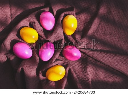 Colorful Easter eggs on a dark burgundy kitchen towel.