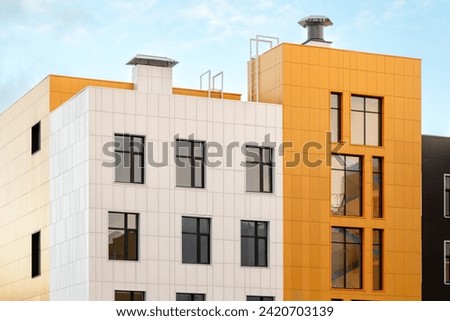 White yellow modern ventilated facade with windows. Fragment of a new typical residential building or commercial complex. Part of urban real estate.