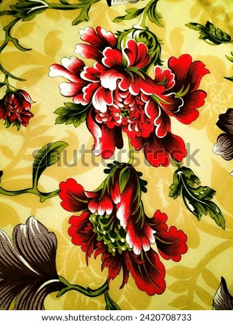 Red flower with grey leaf and green leaves with light brown background. red petals flowers with green seeds and brown background