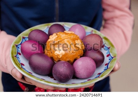 Easter cake and eggs on a plate in children's hands