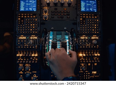Hand of a pilot at the thrust levers of a jet Royalty-Free Stock Photo #2420715347