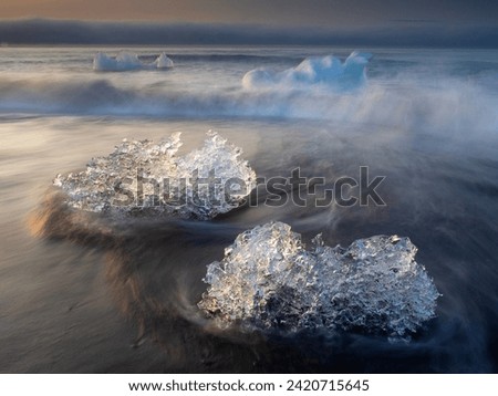 Icebergs floating on Icy beach. Sunrise. South Iceland.