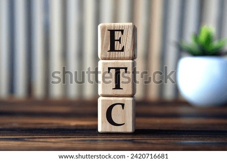 ETC - acronym on wooden cubes on the background of books and a cactus. Medical concept Royalty-Free Stock Photo #2420716681