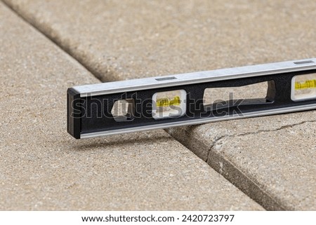 Concrete driveway cracked and settling. Home inspection, slab jacking and sidewalk repair concept. Royalty-Free Stock Photo #2420723797