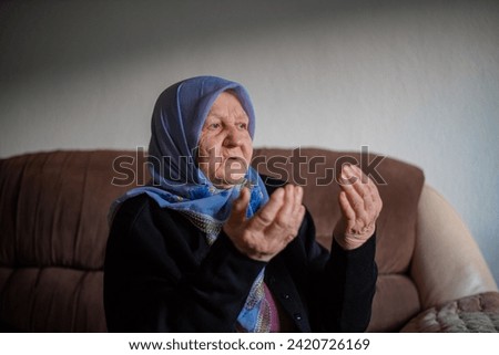 Old muslim woman praying at home. High quality photo