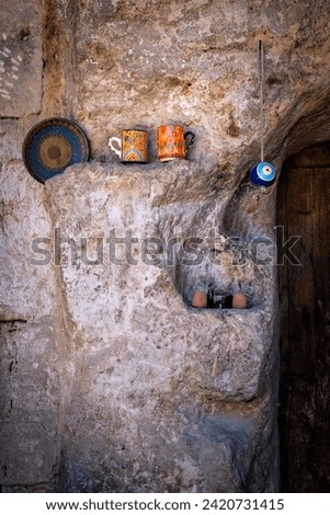 decoration in the doorway of a doorway of a house carved in rock in cappadocia, turkey, some cups, a plate and a tea set with a typical turkish amulet eye, vertical