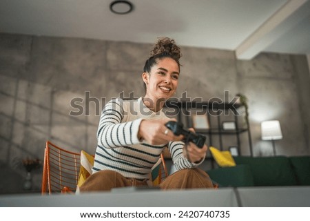 One young caucasian woman play video game console using joystick controller while sitting at home real people leisure concept copy space