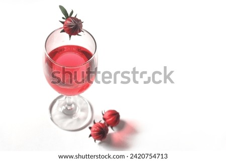 Roselle juice in a wine glass placed on a white background.