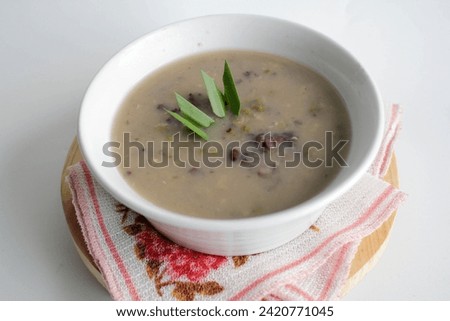 a close up of a bowl of green bean porridge and black sticky rice doused in coconut milk Royalty-Free Stock Photo #2420771045