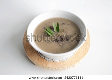 a close up of a bowl of green bean porridge and black sticky rice doused in coconut milk Royalty-Free Stock Photo #2420771111