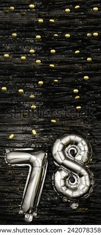 Greeting celebration seventy-eight years birthday. Anniversary number 78 foil silver balloon on black background. Happy birthday, congratulations concept. golden confetti. Vertical banner