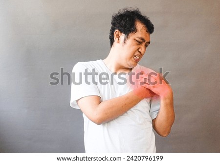 Asian man touch his shoulder feel pain with red sign area . Medical, illness photo concept