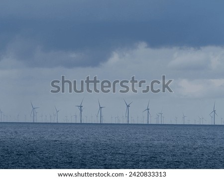 Offshore and Onshore Windmill farm Westermeerwind, Windmill park in the Netherlands with huge large wind turbines, group of windmills for renewable electric energy Royalty-Free Stock Photo #2420833313
