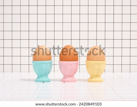 Three eggs in colorful stands. Healthy breakfast and diet. Royalty-Free Stock Photo #2420849103