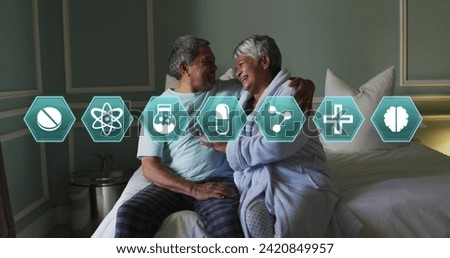 Multiple medical icons against african american senior couple laughing while sitting on bed. medical science research concept