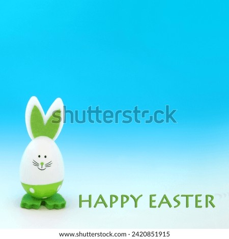 Happy Easter fun green bunny egg on gradient blue white background with text phrase. Minimal cute composition for the spring holiday season with go green theme.