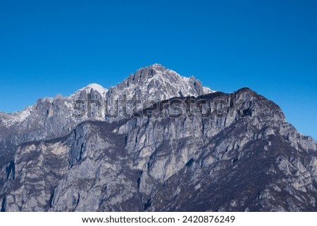 Alpine view: in the foreground, on the right, Mount Coltignone; in the centre, Mount Grigna Meridionale and, on the left, the snow-covered tip of Mount Grigna Settentrionale. Lombardy, Italy