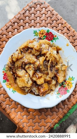 A plate of fried dumplings sprinkled with peanut sauce and soy sauce is ready to eat