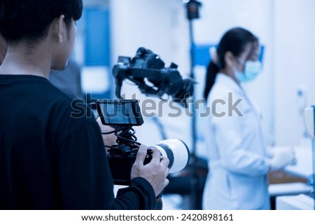 Videographer working with his camera.Professional media production recording at studio.Filming with professional camera concept. Royalty-Free Stock Photo #2420898161