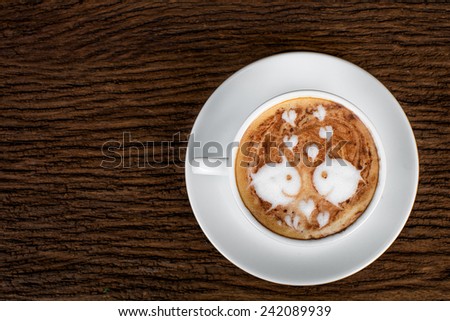 cute two fish latte art coffee cup and beans on grass background