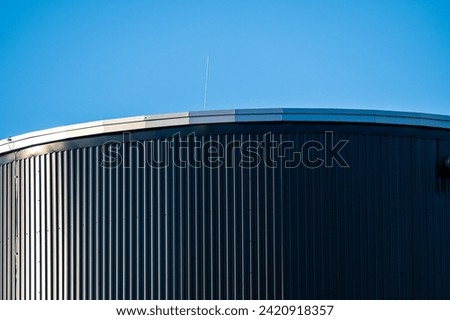 Top of a tall round grey metal tank.