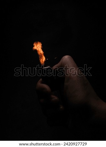 A lighter is being ignited, and a moment frozen in time captures the spark with a burst of light against the profound darkness of the background.