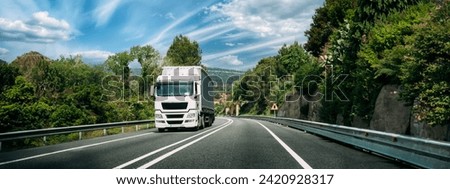 White Truck Or Tractor Unit, Prime Mover, Traction Unit In Motion On Road, Freeway. Asphalt Motorway Highway Against Background Of Hill Landscape. Business Transportation And Trucking Industry