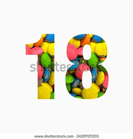 Number eighteen of colourful candies and paper cut in shape of eighteenth digit isolated on white. Rainbow typeface