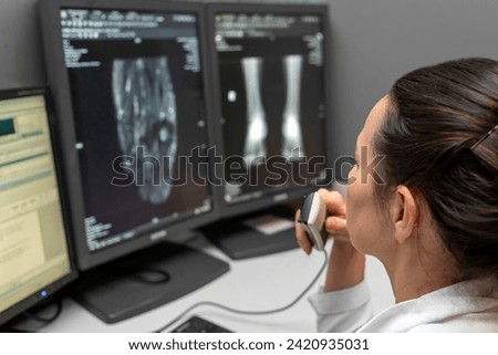 radiology doctor examines foot, ankle x-ray, mr image and reports with microphone looking computer screen, X-ray analysis room reading X-rays of a heel, toe and other parts of the body.	