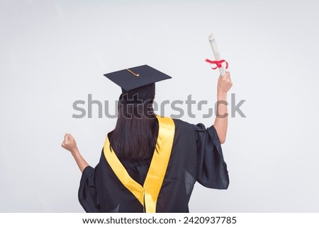 Back view of an upbeat and vivacious female graduate celebrating her diploma of bachelor of science. Feeling triumphant. Isolated on a white background. Royalty-Free Stock Photo #2420937785