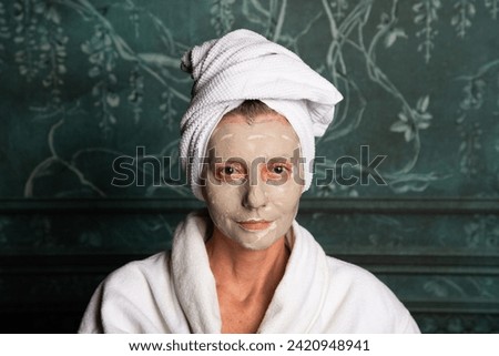 woman applying face mask beauty product