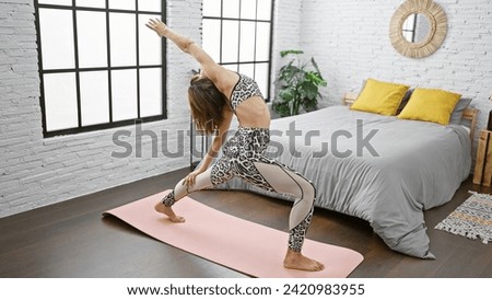 Stunning young hispanic woman keeps fit, training yoga exercises, standing in an apartment bedroom - an athletic lifestyle portrayed inside the room